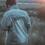 man in gray hoodie standing on field — Foto por DISRUPTIVO na Unsplash