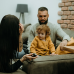 a man sitting on a couch next to a little girl — Foto por Tamara Govedarovic na Unsplash