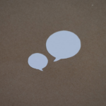 two white speech bubbles sitting on top of a brown surface — Foto por Kelly Sikkema na Unsplash