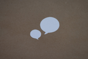 two white speech bubbles sitting on top of a brown surface — Foto por Kelly Sikkema na Unsplash