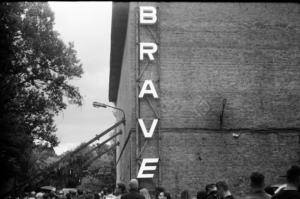Large letters spell out brave on brick building — Foto por Lizgrin F na Unsplash
