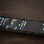 a close up of a cell phone on a table — Foto por Lana Codes na Unsplash