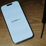 A cell phone sitting on top of a wooden table — Foto por appshunter.io na Unsplash