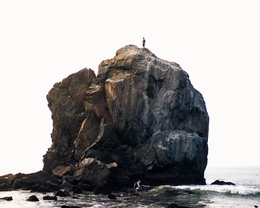 person standing on rock near ocean during daytime — Foto por Winggo Tse na Unsplash